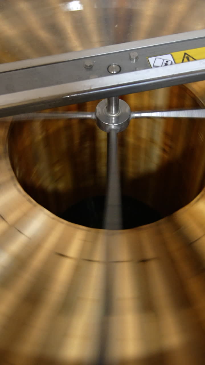 Honey frames rotating inside the machine. Electric equipment for pumping honey at apiary. View from top. Vertical video