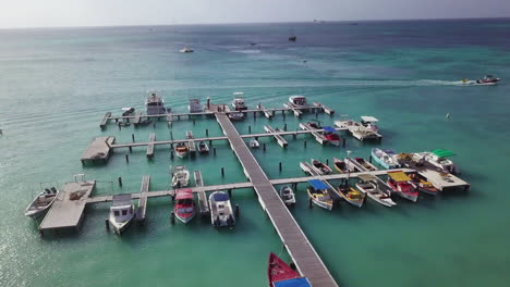boats at a dock in the beautiful blue caribbean sea in palm beach, aruba