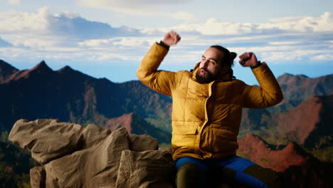 satisfied pleased hiker reaching the top of the mountain and being tired