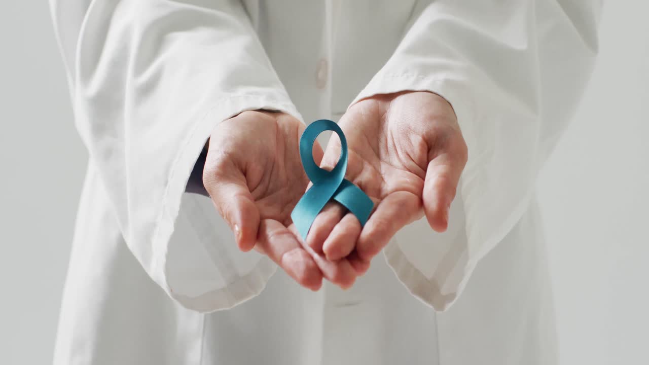 Video del busto di un medico caucasico che tiene un nastro blu per la consapevolezza del cancro ovarico.