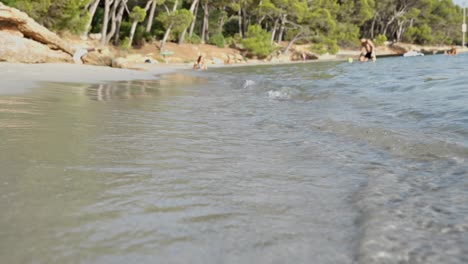 Playa-De-Arena-Con-Pequeñas-Olas-Y-Gente-En-El-Fondo-De-La-Isla-De-Platja-De-Formentor-Mallorca