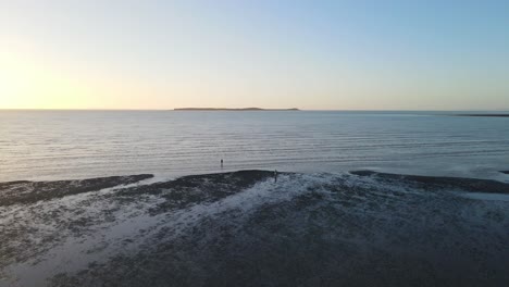 People-At-The-Beach-During-Low-Tide-At-Sunset-With-Calm-Sea---Clairview-Beach-In-Queensland,-Australia