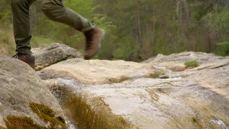 Adventurous-hiker-jumping-across-the-rocks-along-the-Route-of-the-Seven-Pools---Catalonia-Spain---Outdoor-Adventure-Travel-Concept