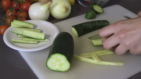 cortar un pepino fresco en juliana cortado con un cuchillo en la tabla de cortar