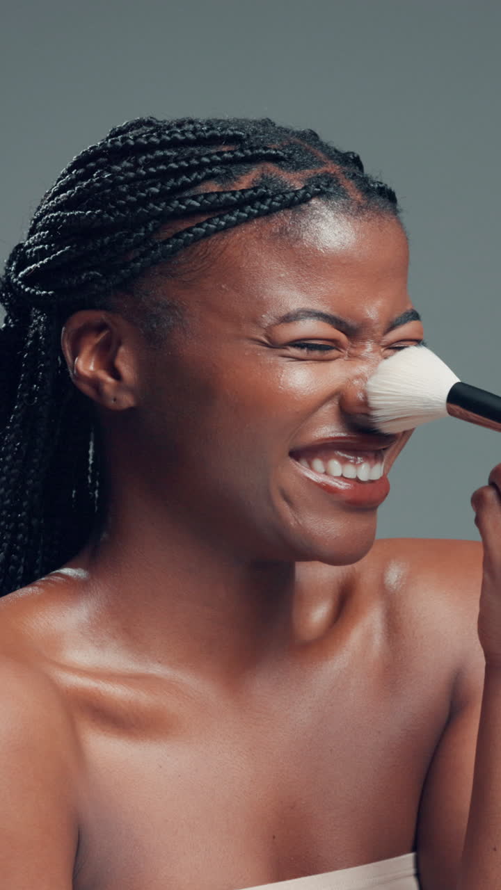 Smiling Young Woman Applying Makeup with a Brush