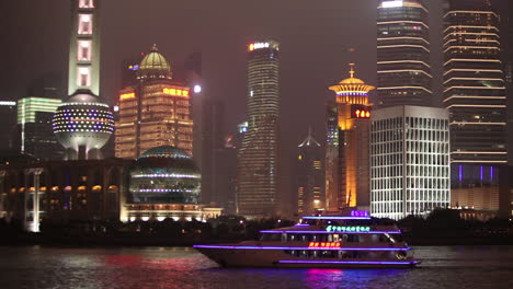 The-vivid-night-skyline-of-Shanghai-China-with-river-traffic-foreground