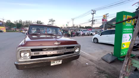 classic car driving through bustling street scene