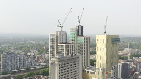 toma aérea de drones del paisaje urbano de woking una ciudad en inglaterra con rascacielos de gran altura y obras de construcción de grúas con drones dando vueltas