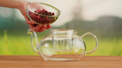 preparing rose tea in a glass teapot