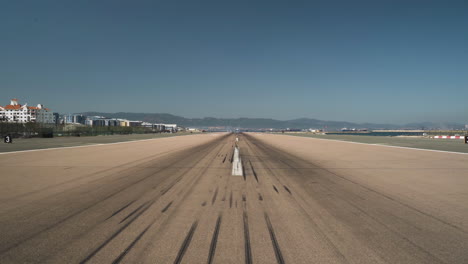 Empty-runway-with-tire-marks-at-Gibraltar-airport,-cloudless-sky-above