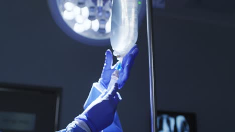 doctors in protective clothing and face masks preparing patient for surgery in operating theatre