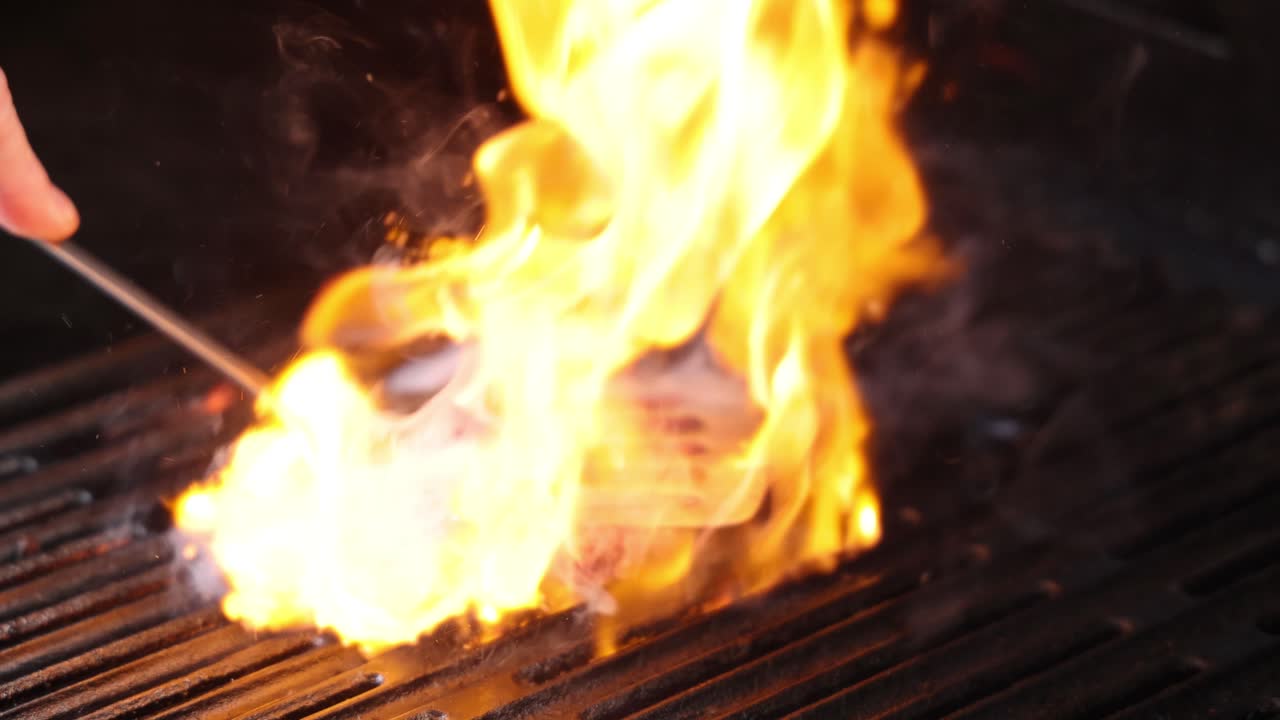 Hamburger alla griglia con fiamme intense