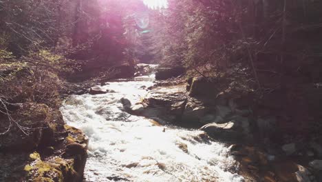 aerial view of a mountain river with beautiful waterfall in the afternoon sunlight