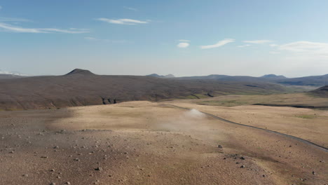 Vogelauge-Fliegt-über-Dem-Auto,-Das-Offroad-Durch-Die-Ländliche-Landschaft-In-Island-Fährt.-Erstaunliche-Mondlandschaft-Isländische-Landschaft-Mit-Fahrzeugfahrender-Staubstraße,-Die-Das-Hochland-Erkundet