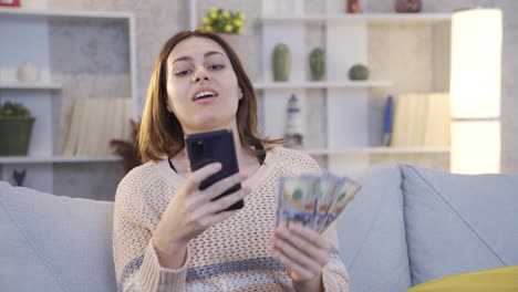 mujer joven feliz comprando en línea en el teléfono inteligente. dinero y concepto de compras.