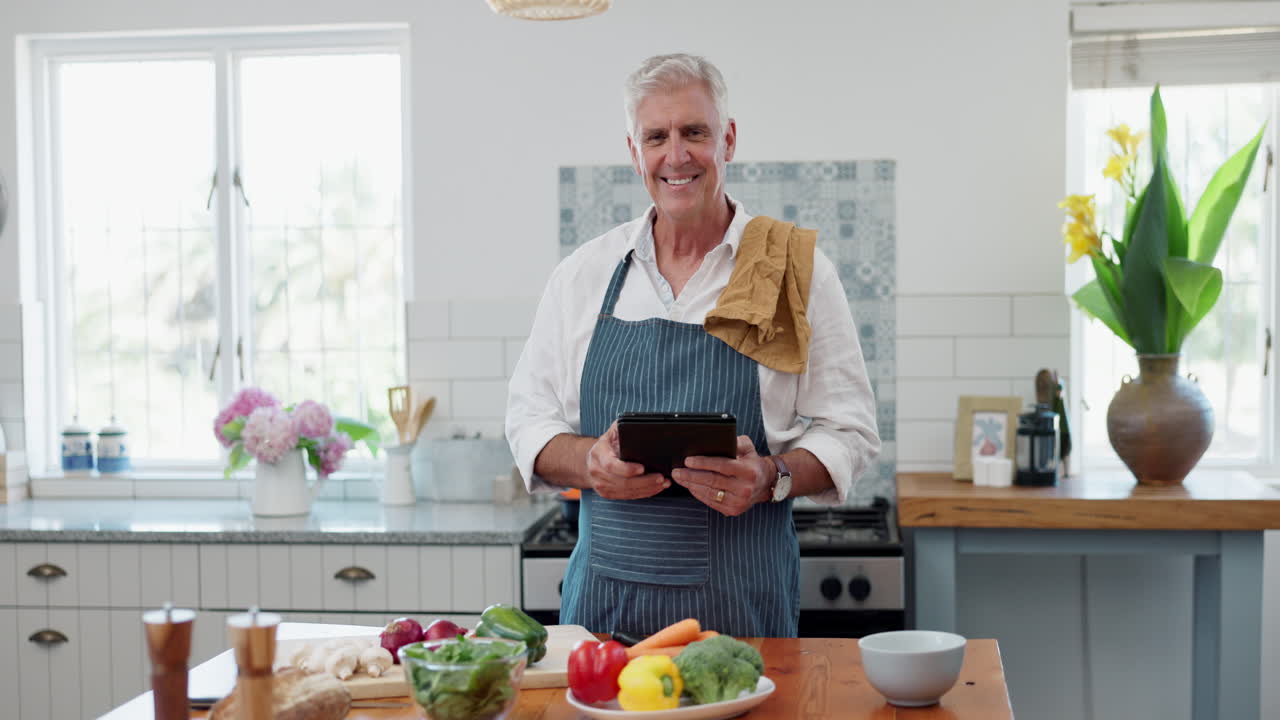 hombre mayor cocinando con una tableta en la cocina