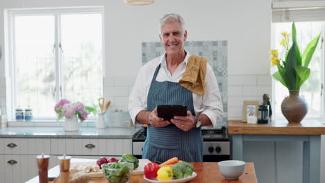 hombre mayor cocinando con una tableta en la cocina