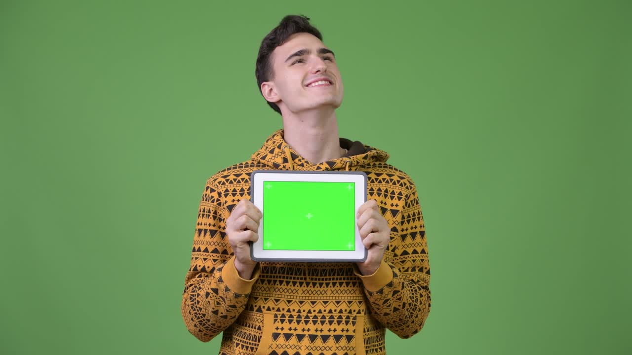 Young handsome man thinking while showing digital tablet