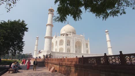 vista desde la pasarela lateral al majestuoso taj mahal rodeado por los minaretes de mármol blanco - amplia dolly revela el tiro