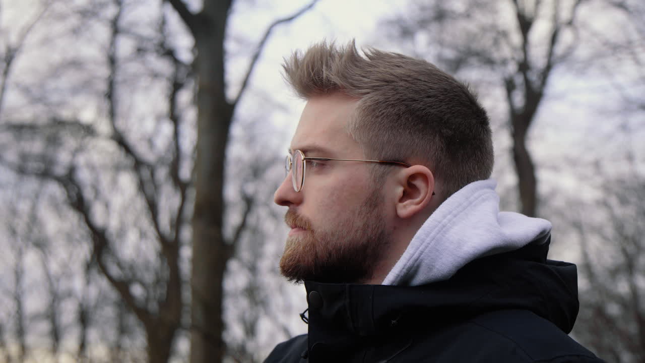 joven varón caucásico bebiendo café caliente de una taza sostenible fuera de vidrio