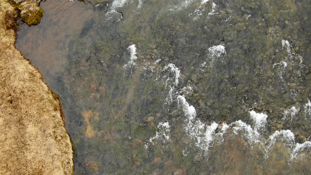 vista aérea sobre un río salvaje y una cascada en un hermoso paisaje - islandia
