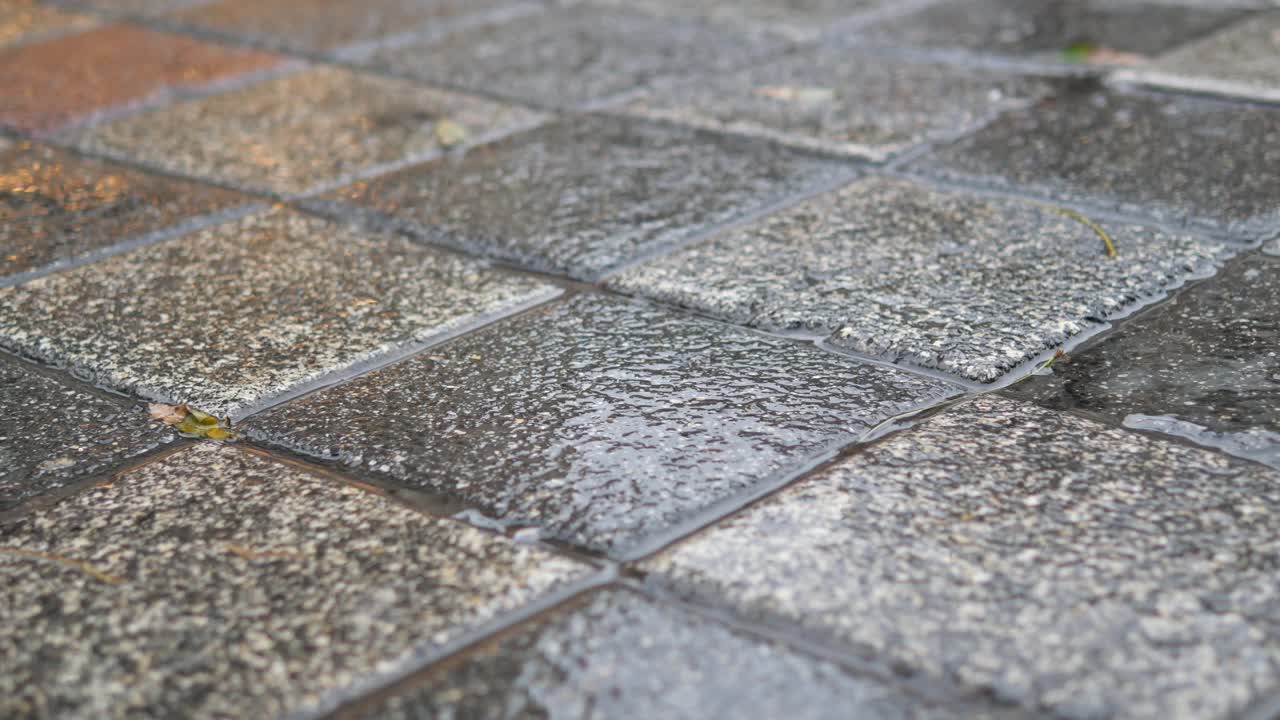 Person Walking on Wet Pavement in the Rain