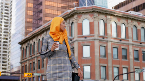 vista frontal de una joven mujer asiática en hijab de pie en la ciudad 4k