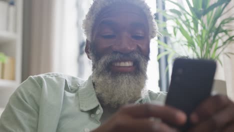 Video-of-african-american-senior-man-using-smartphone