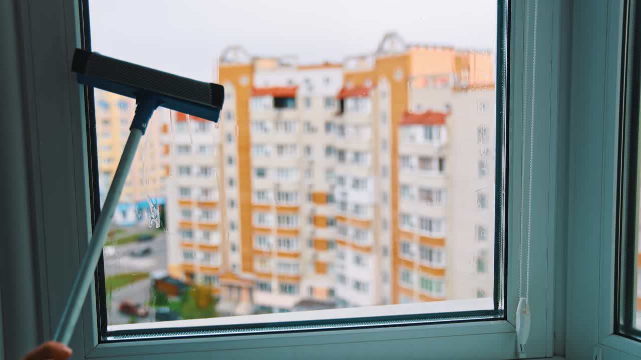 Glass cleaner working with wet windows. Window cleaning with water and devices.