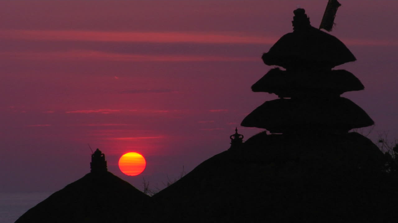 el templo de pura tanah lot se destaca en silueta contra un cielo brillante 3