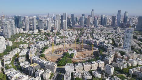 Vista-De-Paralaje-A-Gran-Altitud-De-La-Construcción-De-Un-Proyecto-De-Plaza-De-Gran-Ciudad---Rascacielos-En-El-Fondo