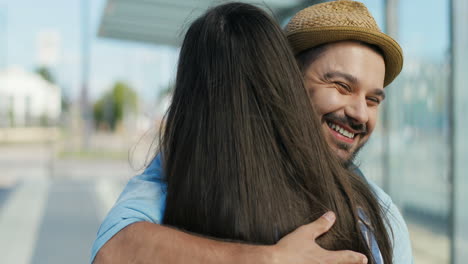 Vista-Trasera-De-Una-Mujer-Caucásica-Reunida-Y-Abrazando-A-Un-Amigo-Viajero-Caucásico-En-La-Estación-De-Tren