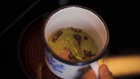 cup with a seasoning broth of herbs