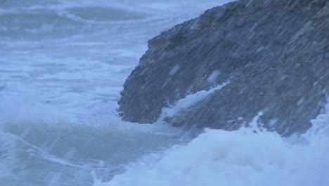 Big-stormy-waves-breaking-against-abandoned-seaside-fortification-building-ruins-at-Karosta-Northern-Forts-in-Liepaja,-slow-motion-medium-closeup