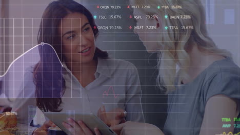 animation of stock market data processing over two diverse female colleagues discussing at office