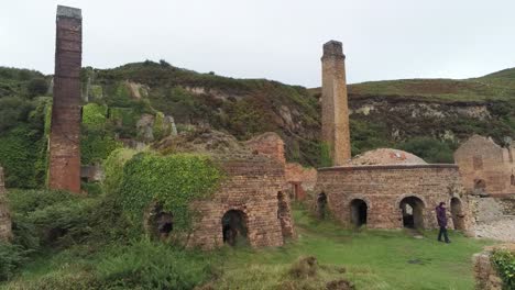 Porth-Wen-aerial-rising-forward-view-abandoned-Victorian-industrial-brickwork-factory-remains-on-Anglesey-eroded-coastline