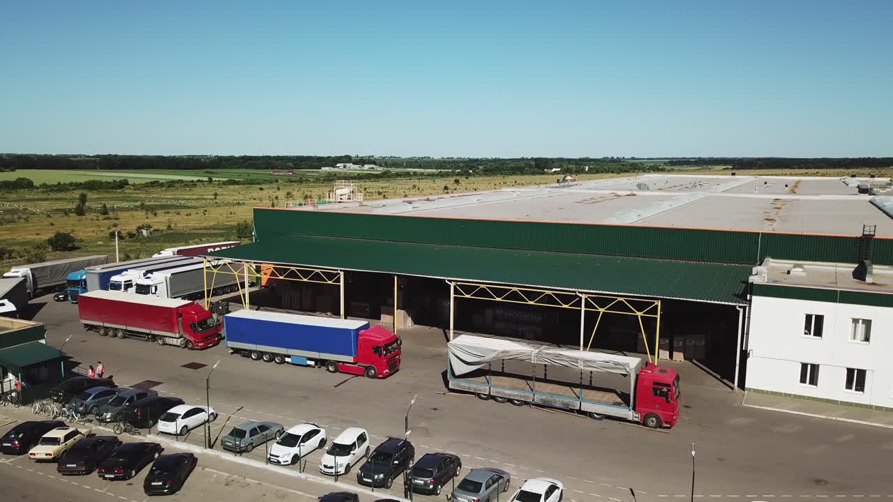 Aerial view of a big factory and a parking lot in the front.