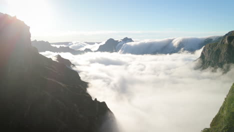 flying-in-mountain-landscape-of-Madeira-island-above-clouds,-sunny-Portugal