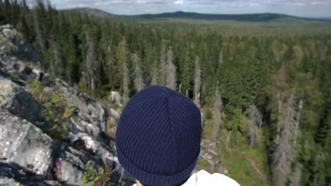 person looking out at scenic mountain view from a rocky outcrop