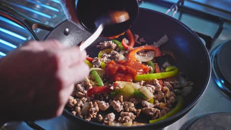 adding tomato sauce to ground turkey and bell pepper in pan