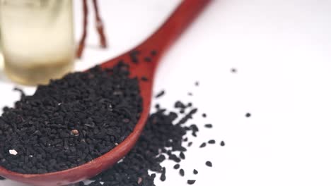 black cumin seeds in wooden spoon with oil