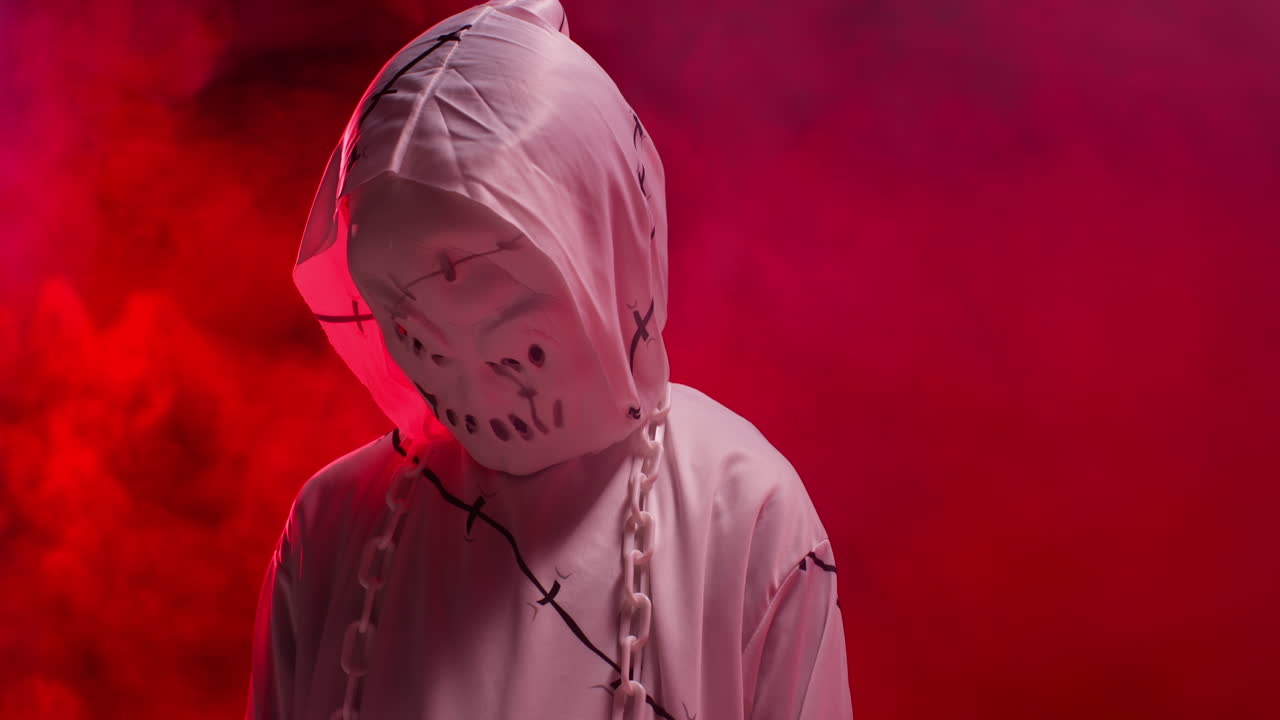 ребёнок в костюме призрака зомби монстра трюк или угощение на хэллоуин пугает людей на фоне красного дыма 5