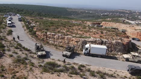 Israel-Army-squad-soldiers-on-Humvee-vehicles-leaving-for-training,-Aerial-shot