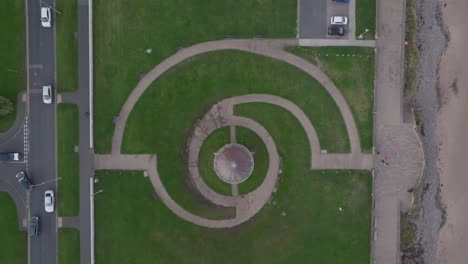 overhead view of geometric circular pathways in grassy coastal park