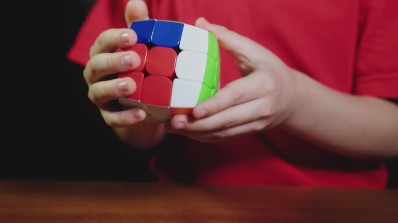 las manos del niño resolviendo el rompecabezas del cubo de rubik