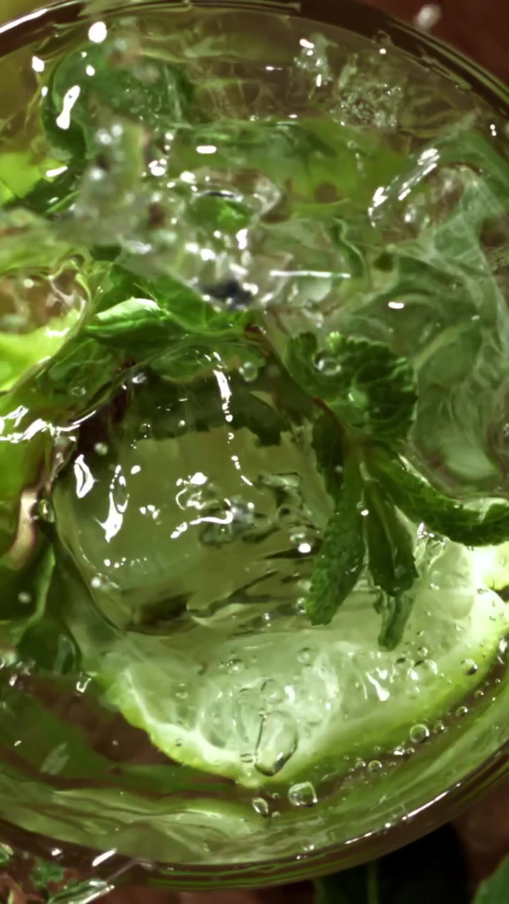 Hidastettu jääpala putoamassa virkistävään Mojito-juomaan