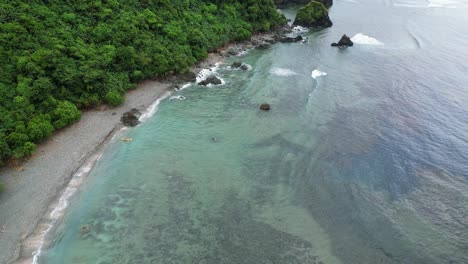 Small-yellow-fisher-boat-stranded-at-exotic-beach-with-rainforest-jungle,-aerial