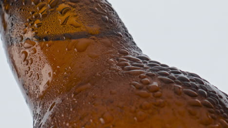 water drops beer bottle flowing in super slow motion closeup. cold alcohol drink