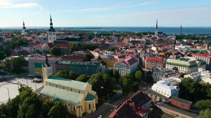 Una ripresa panoramica con drone di Tallinn, Estonia, in Europa, Paesi Baltici, in 4K, che mostra vecchie chiese, edifici medievali con tetti rossi e il Mar Baltico sullo sfondo con cielo blu e nuvole