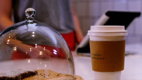 camarera ofreciendo una taza de café en el mostrador